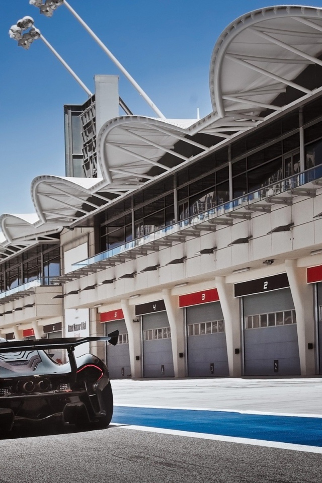 Черный McLaren P1 у ангаров