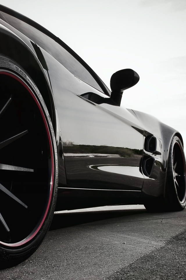 Черный автомобиль перед дорожными знаками