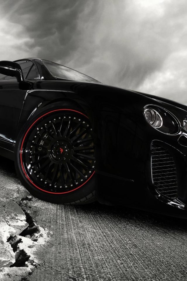 Черный автомобиль на треснувшем асфальте