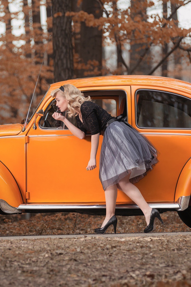 Девушка красит губы у зеркала старого автомобиля