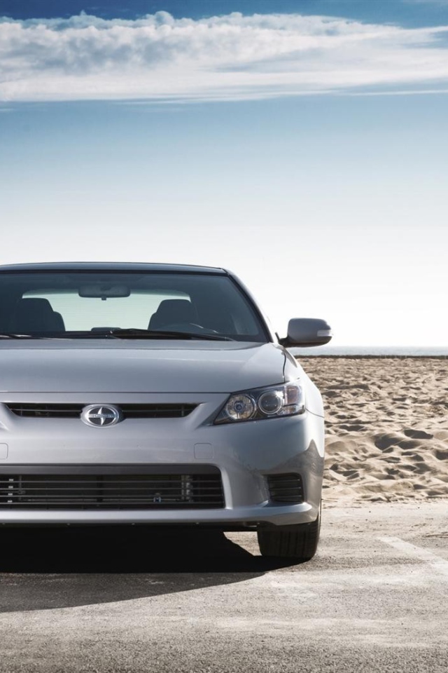 Серый Scion на фоне песка