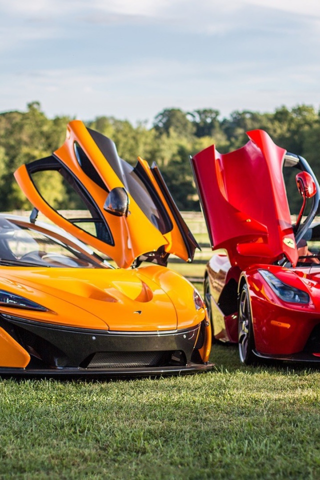 Красный Ferrari LaFerrari и оранжевый Макларен на газоне