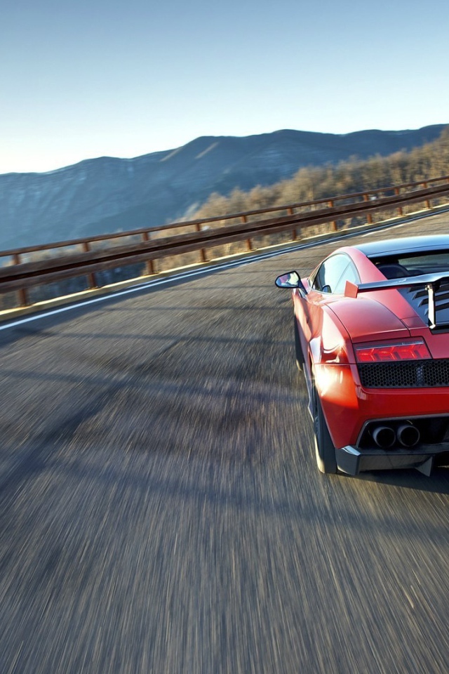 Красный гоночный автомобиль на горной дороге