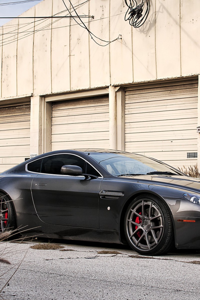 Автомобиль Aston Martin у складского здания