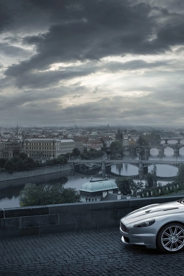 Серый Aston Martin на фоне города