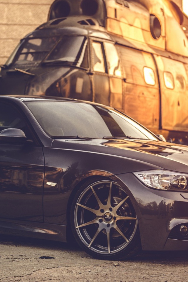 Черный БМВ на фоне вертолета