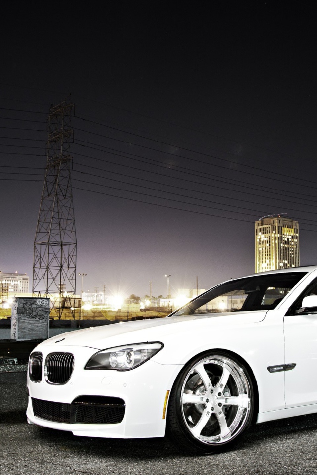 Белый БМВ на фоне ночного города