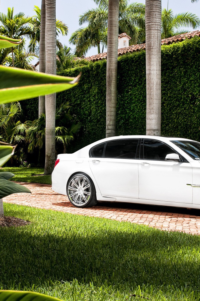 Белый БМВ во дворе богатого дома