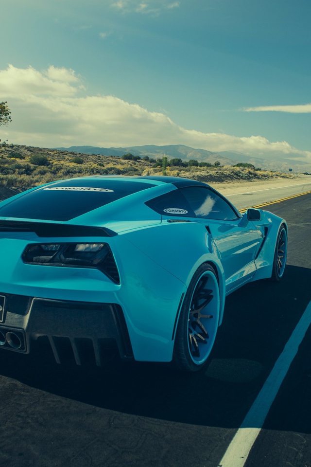 Голубой спортивный Chevrolet на шоссе в жаркой пустыне