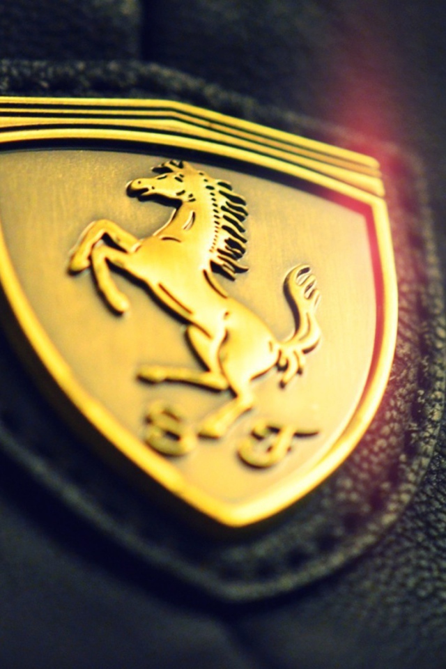 Золотой символ Ferrari на черной коже