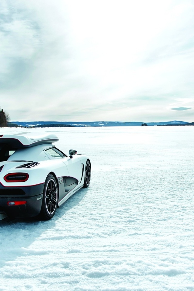 Белый Koenigsegg на заснеженном поле