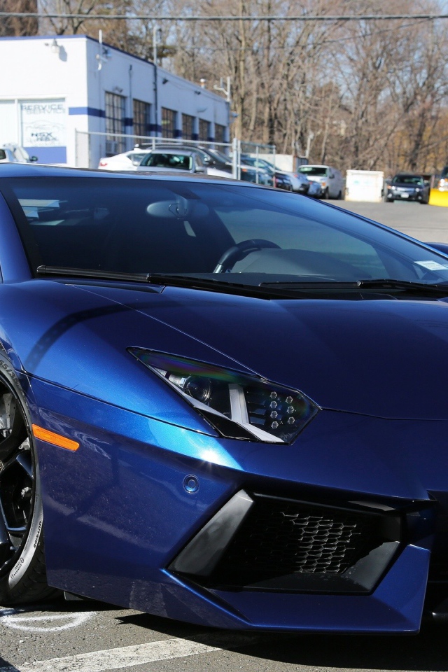 Темно синий автомобиль Lamborghini Aventador припаркован на улице