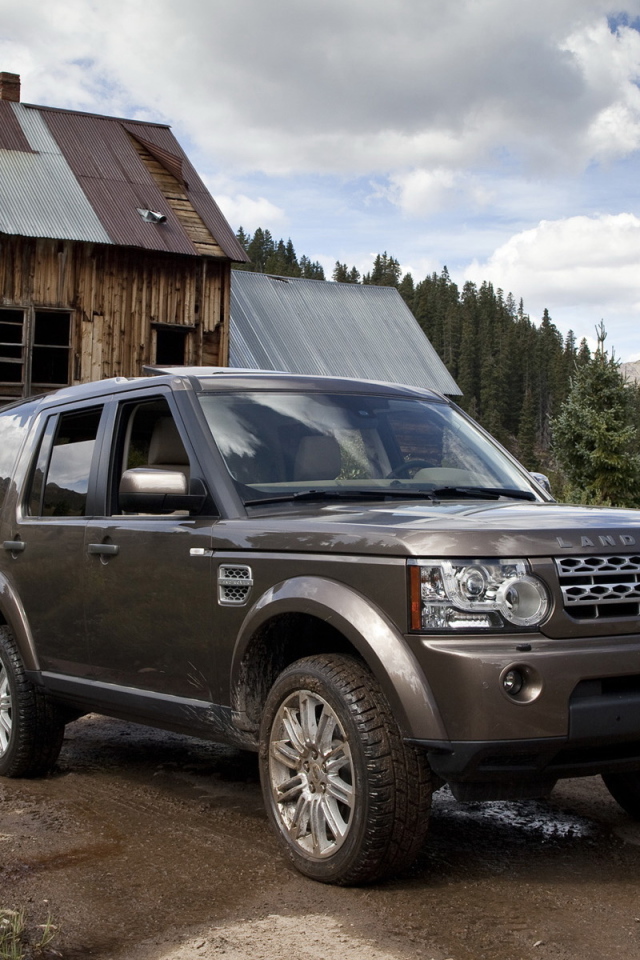 Темный Land Rover на фоне старого здания
