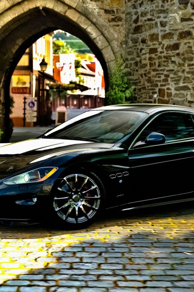 Черный Maserati gran turismo у каменной арки