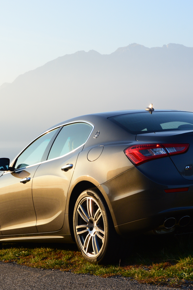 Коричневый Maserati на фоне гор