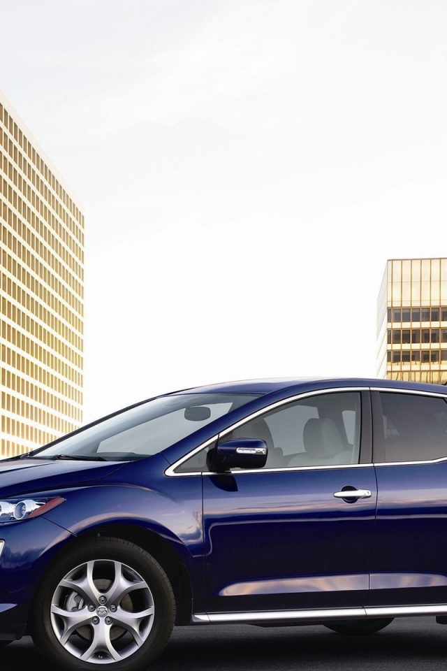 Семейный автомобиль Мазда на фоне городских зданий