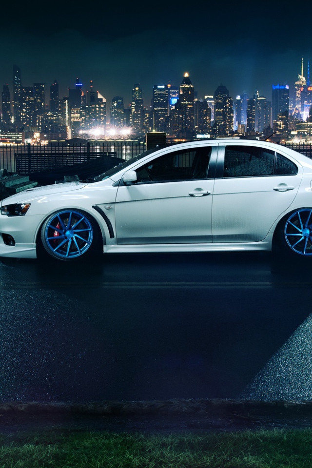 Автомобиль Mitsubishi Lancer Evo X на фоне города
