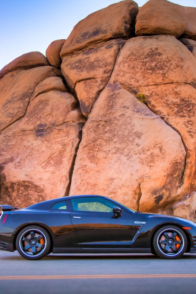 Черный Nissan GT-R у подножия скалы