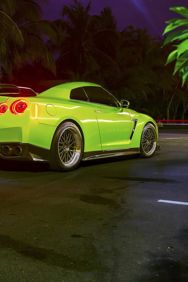 Зеленый спортивный Nissan на ночной улице города