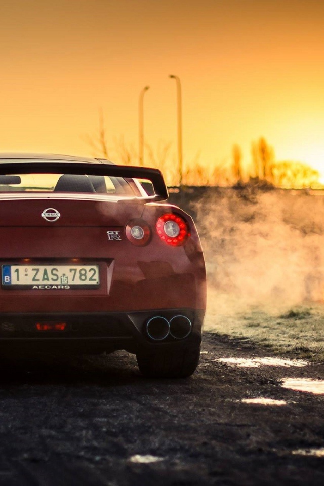 Красный Nissan у реки на рассвете