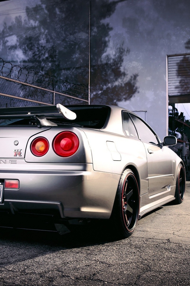 Серебристый Ниссан перед воротами