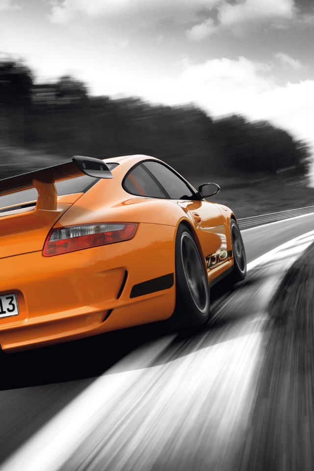 Оранжевый Porsche GT3RS на сером шоссе