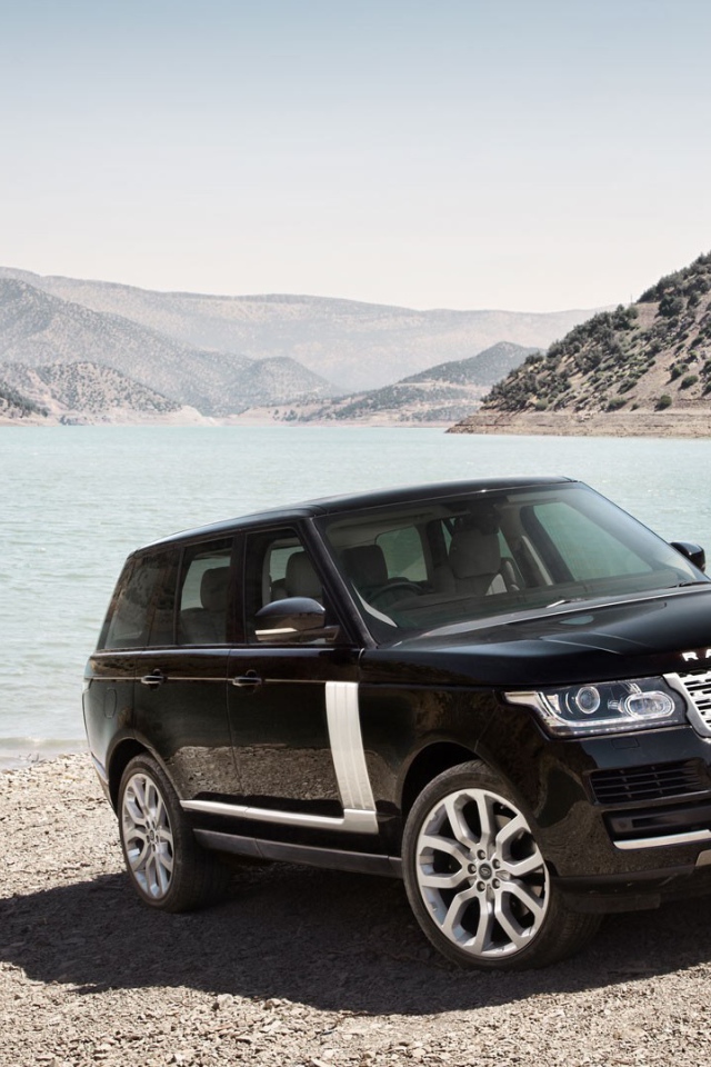 Черный Range Rover на берегу водоема