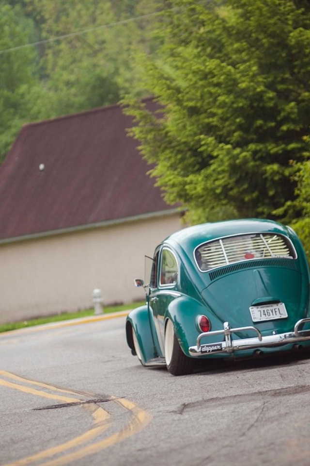 Зеленый Volkswagen Beetle на дороге