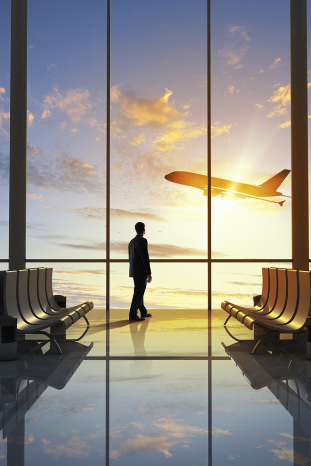 Мужчина смотрит в окно на взлетающий самолет