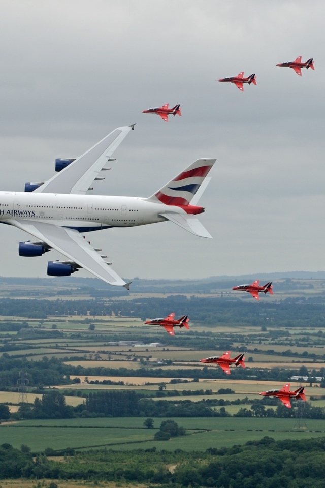 Airbus A380 в сопровождении красных истребителей