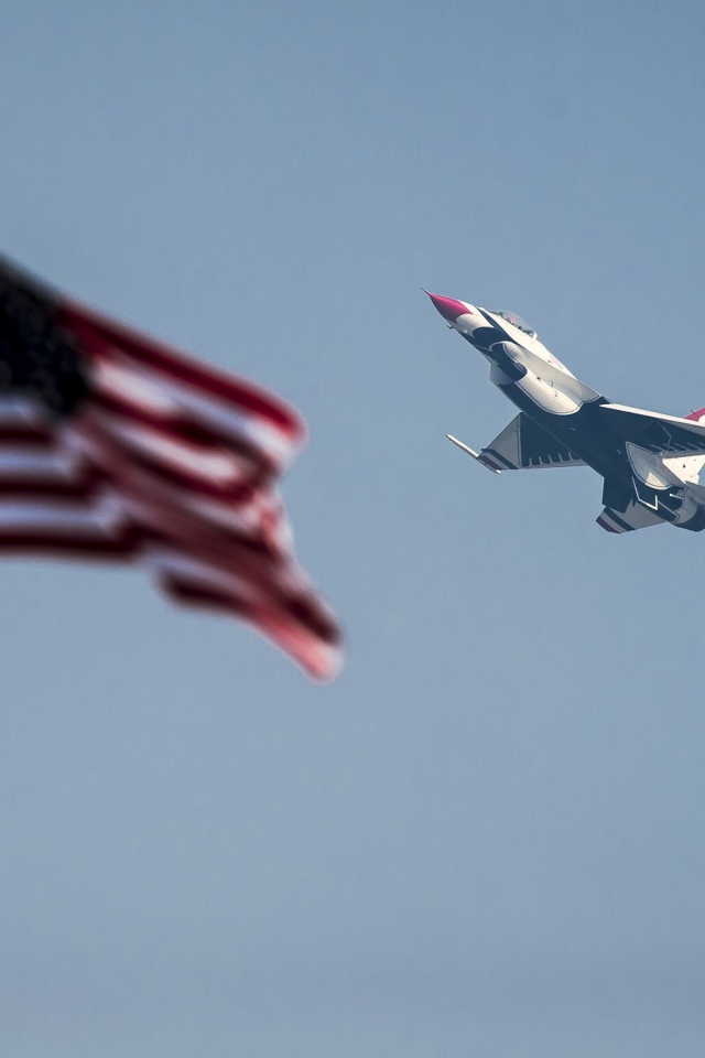 Истребитель F-16 Fighting Falcon пролетает над флагом США