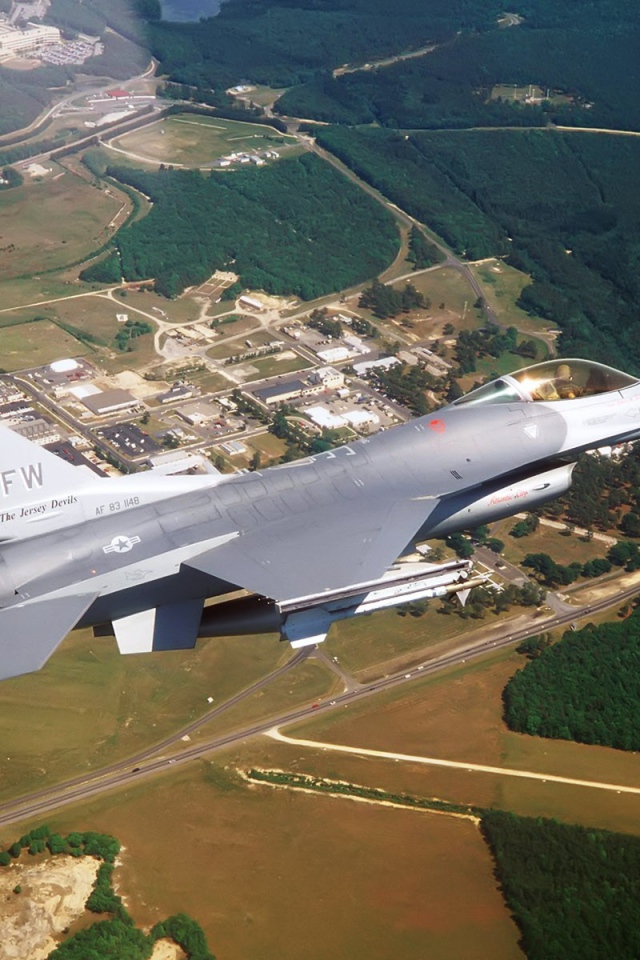 Истребитель F-16 выполняет маневр над землей