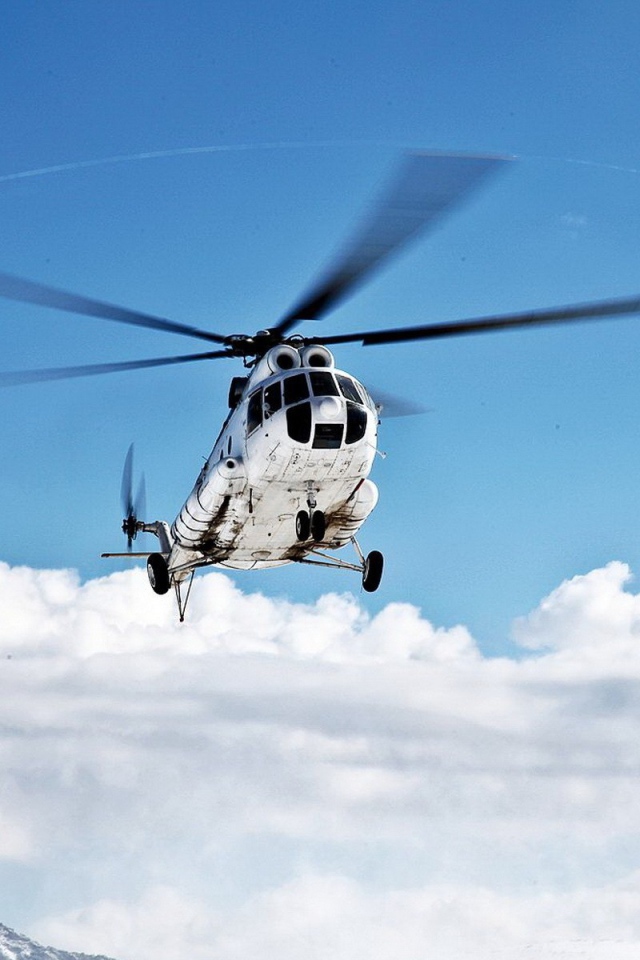 Вертолет на фоне облаков в горах