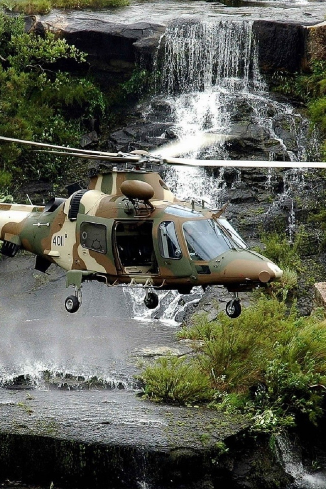 Военный вертолет над водопадом