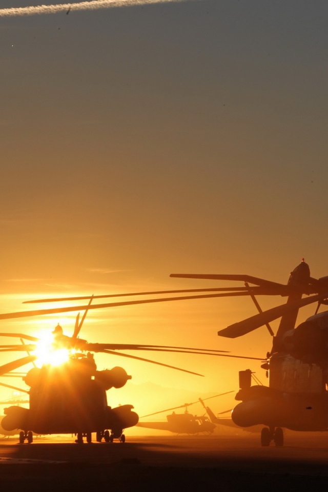 Несколько вертолетов на фоне заката