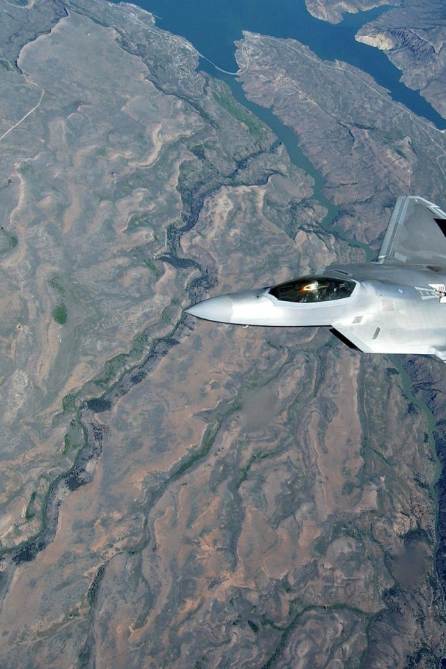 Самолет F-22 Raptor над поверхностью земли