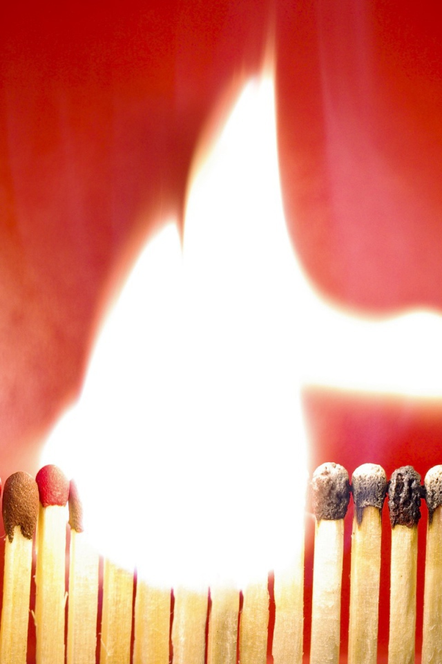 Горящий ряд спичек на красном фоне
