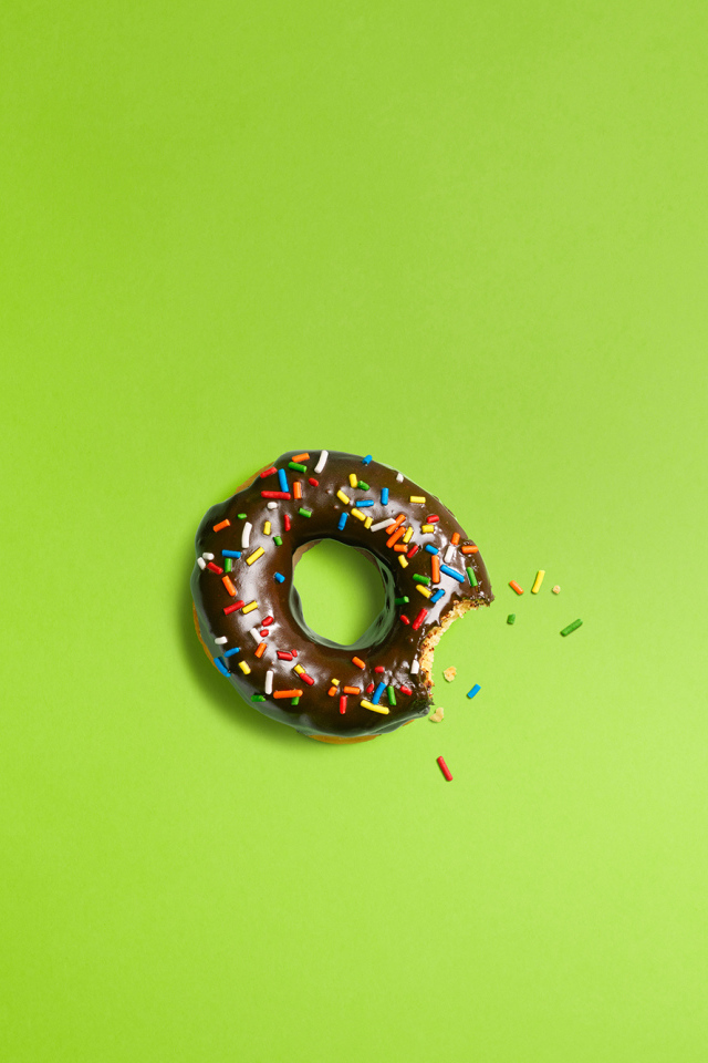 Шоколадный пончик на зеленом фоне