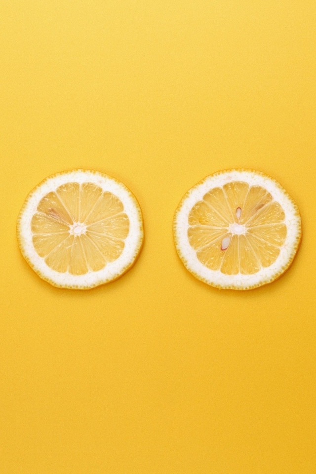 Кружки лимона, желтый фон