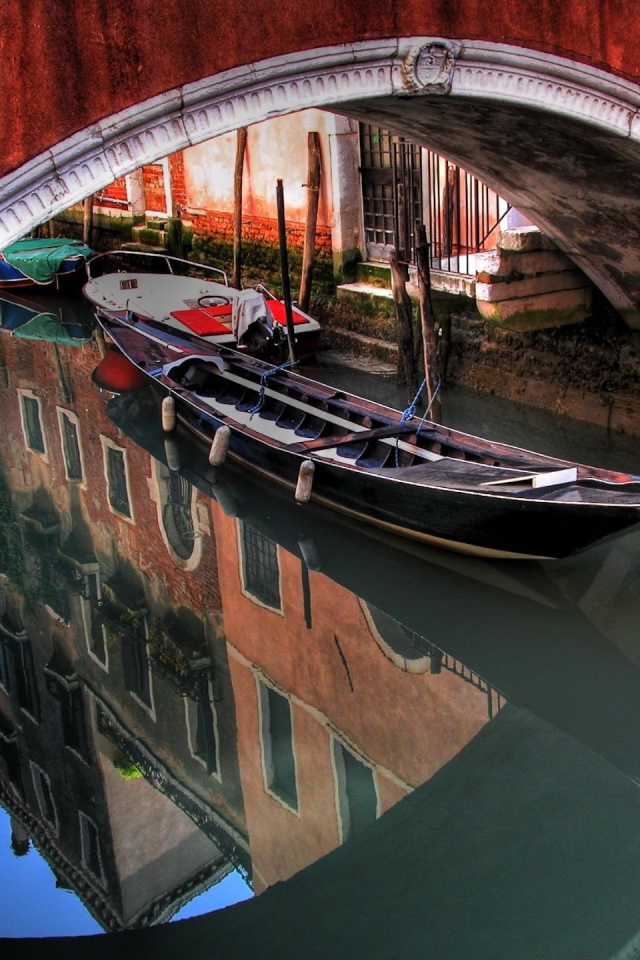Лодка под красным мостом в Венеции