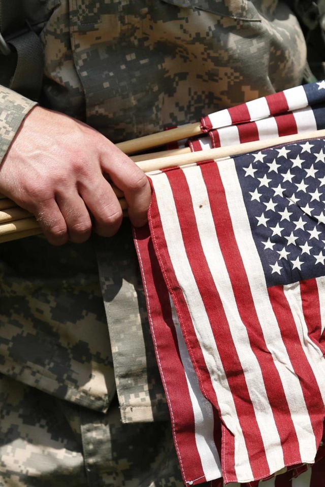 Солдат держит в руке флаги США