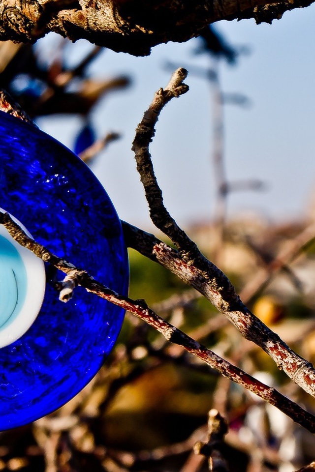 Оберег из синего стекла на дереве