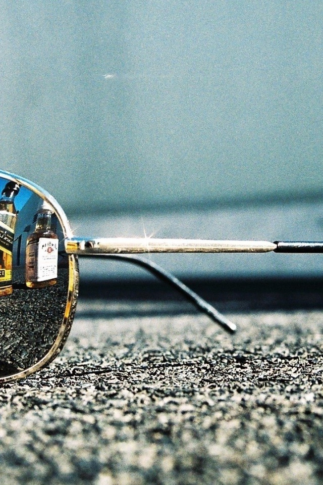 Бутылки с алкоголем отражаются в очках