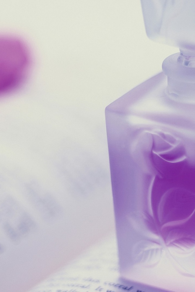 Флакон духов на открытой книге