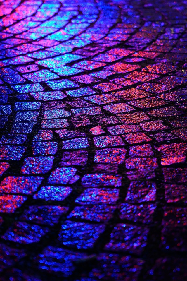 Блики ночных огней на брусчатке улицы