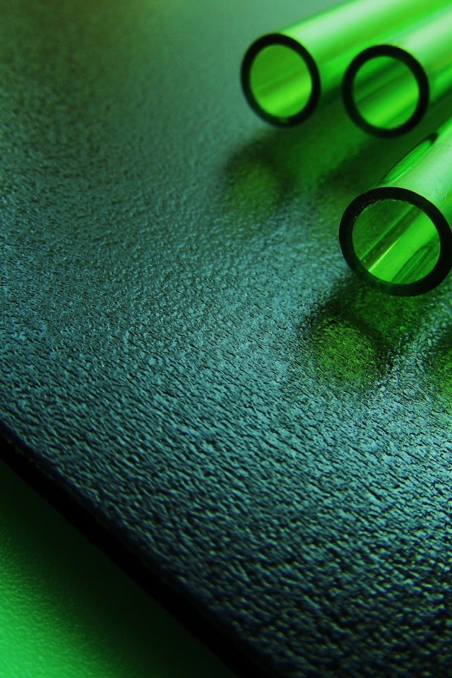 Трубки из зеленого стекла на черной плите