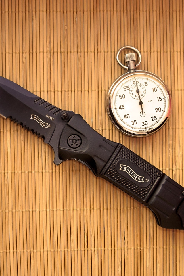 Часы и нож на бамбуковом коврике