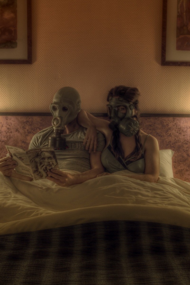 Семейная пара лежит в кровати в масках