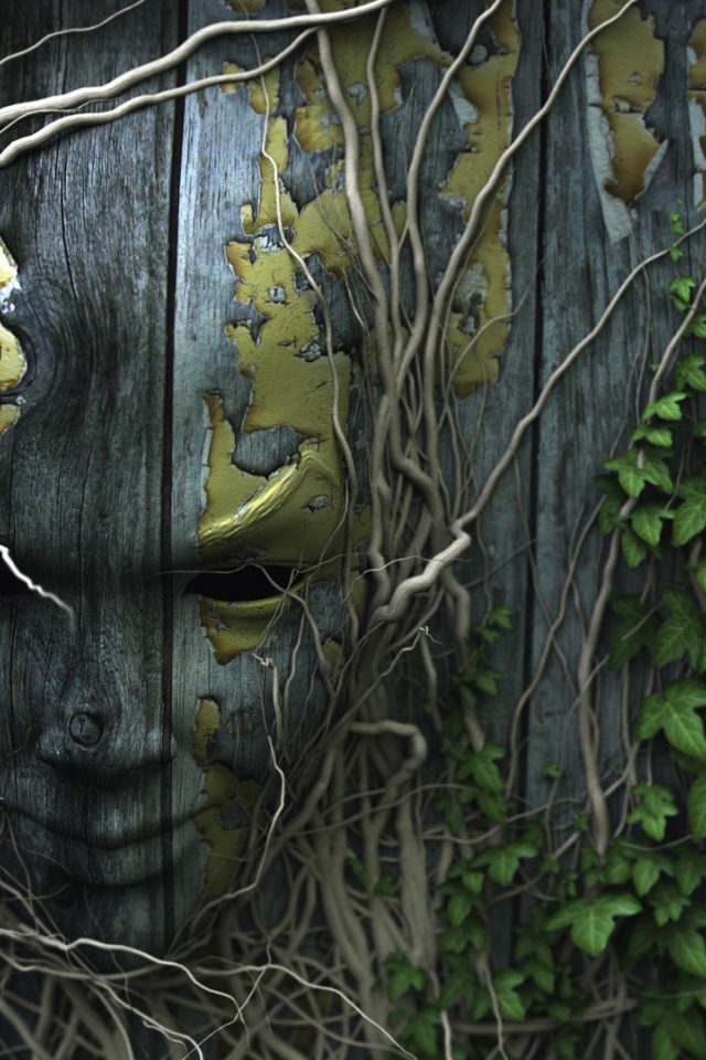 Лицо на деревянном заборе, увитое плющом