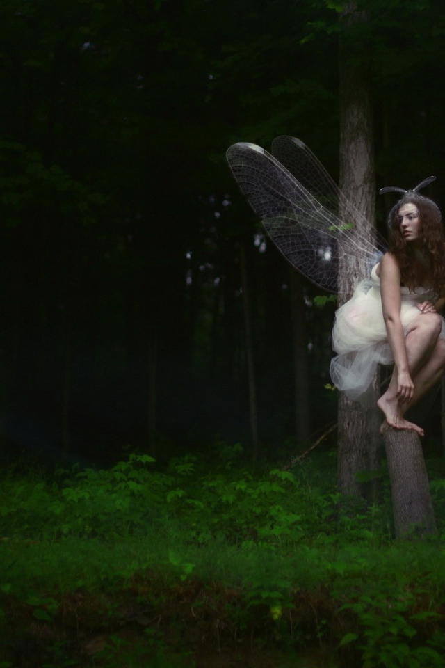 Девушка фея среди деревьев в чаще леса